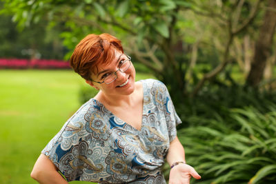 Portrait of smiling woman standing on field 