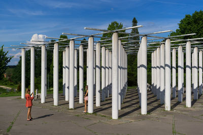 Wooden fence by trees against sky