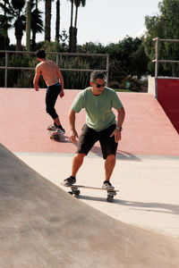 Men riding skateboard in urban street skatepark. casual guy wearing shorts and t-shirt.