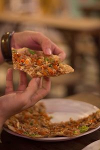 Close-up of hand holding pizza