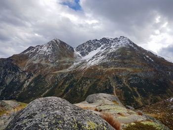 Scenic view of mountains against cloudy sky