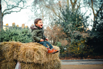 Full length of boy with plants against trees