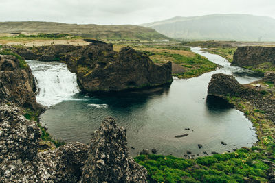 Scenic view of river amidst mountains against sky