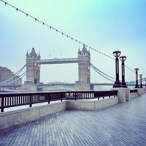 clear sky, architecture, built structure, connection, bridge - man made structure, building exterior, copy space, bridge, railing, bird, city, river, engineering, suspension bridge, sky, outdoors, water, day, cable, no people