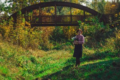 Full length rear view of woman standing on grass