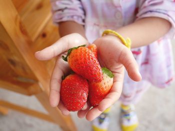 Close-up of hand holding strawberries