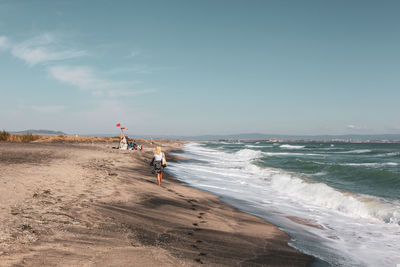 People on beach against sky