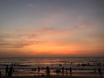 Group of people on beach during sunset
