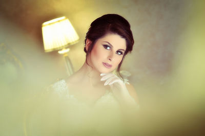 Portrait of bride sitting on chair against wall