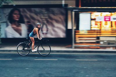 Side view of woman riding bicycle on road