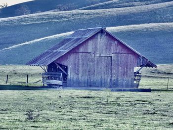 Old barn on field by building