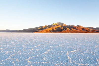 Scenic view of snowcapped mountains against clear blue sky