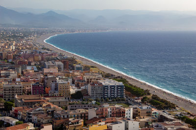 High angle view of townscape by sea against sky