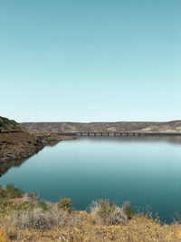 Scenic view of lake against clear blue sky