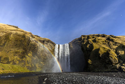 Scenic view of waterfall against sky