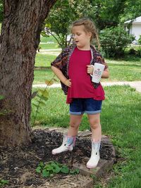 Full length of a girl standing on tree trunk