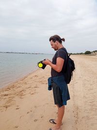 Full length of man holding ball on beach