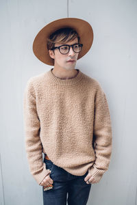 Full length of young man standing against wall