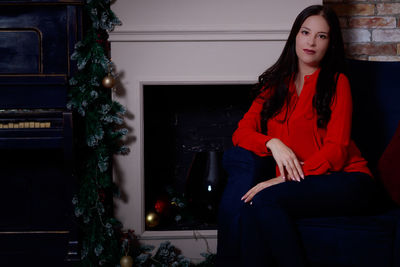 Young woman sitting on sofa at home