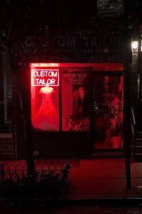 Red information sign on wall in city at night