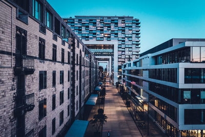 Street amidst buildings against blue sky