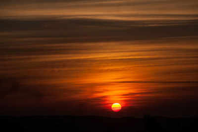 Scenic view of silhouette landscape against orange sky