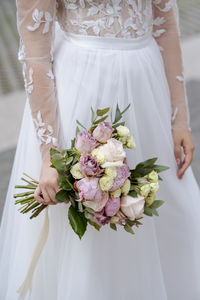 Midsection of woman holding flower bouquet