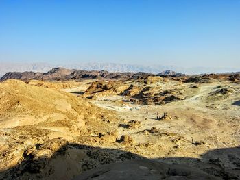 Scenic view of desert against clear blue sky