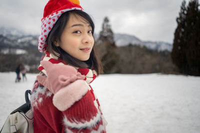 Portrait of girl standing on snow covered land