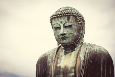 Close-up of statue against temple against sky