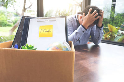 Tensed businessman with documents sitting at office