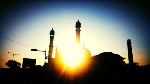 Low angle view of sun shining through clouds