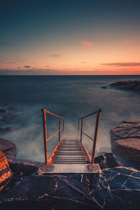 High angle view of steps leading towards sea against sky