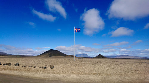 National flag in desert against sky
