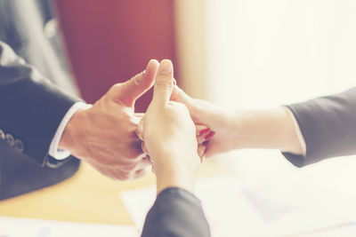 Midsection of couple holding hands