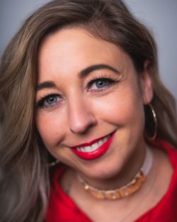 Close-up portrait of smiling woman against gray background