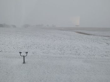 Scenic view of snowy field against sky during winter