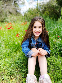 Portrait of young woman sitting on field