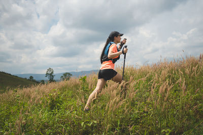 Full length of woman standing on field against sky