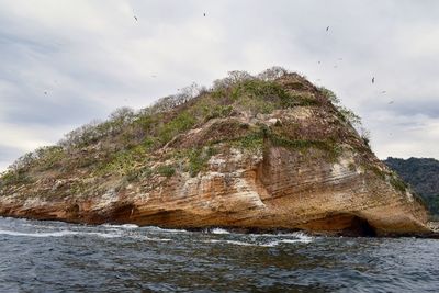 Scenic view of rocks in sea against sky