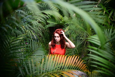 Portrait of young woman against plants