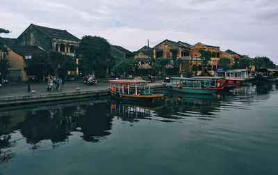 Boat moored in thu bon river against cloudy sky