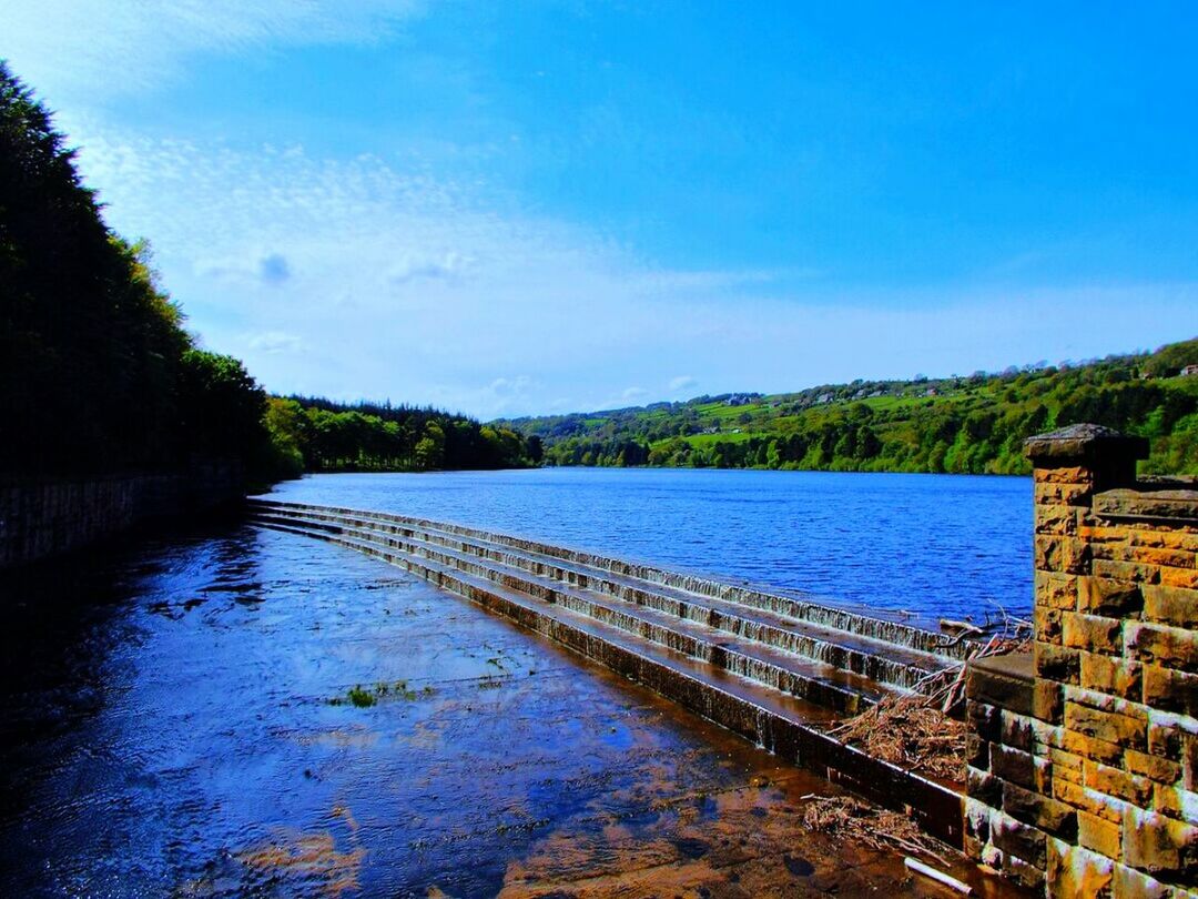 water, sky, tranquility, tranquil scene, tree, river, blue, reflection, built structure, lake, scenics, nature, beauty in nature, connection, architecture, day, bridge - man made structure, no people, transportation, outdoors