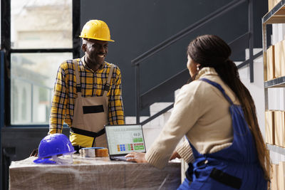 Rear view of young man standing in factory