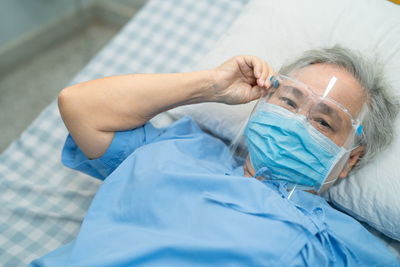 High angle view of man resting on bed