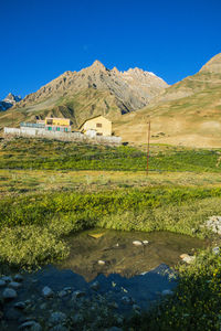 Scenic view of lake and mountains against clear blue sky