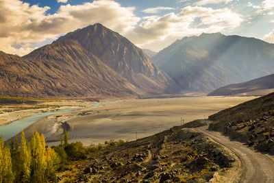 Scenic view of lake by mountains against sky