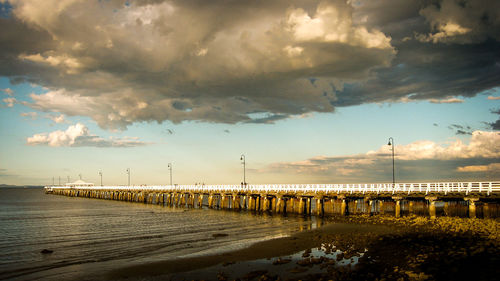 Pier over sea against sky during sunset