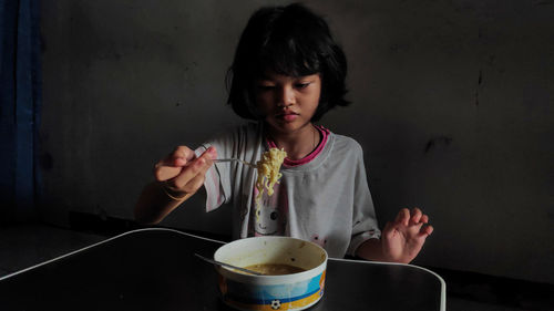 Little asian girl enjoy eating with some noodles on a bowl in lunch time, delicious face.