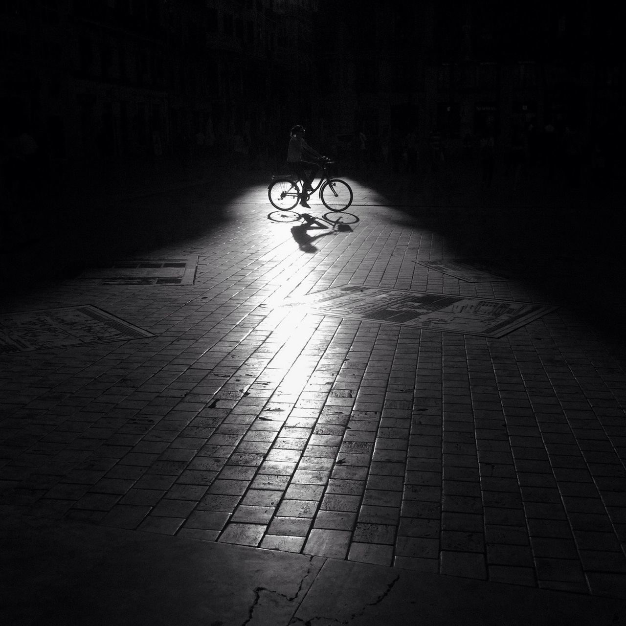 the way forward, night, shadow, street, walking, cobblestone, indoors, dark, unrecognizable person, illuminated, men, built structure, tiled floor, paving stone, sunlight, architecture, wall - building feature, bicycle